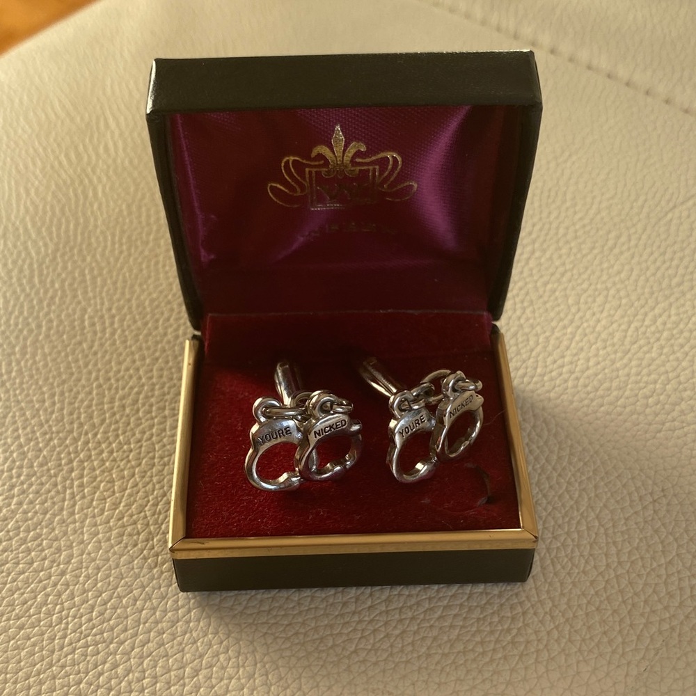 Silver style handcuff cuff links.
